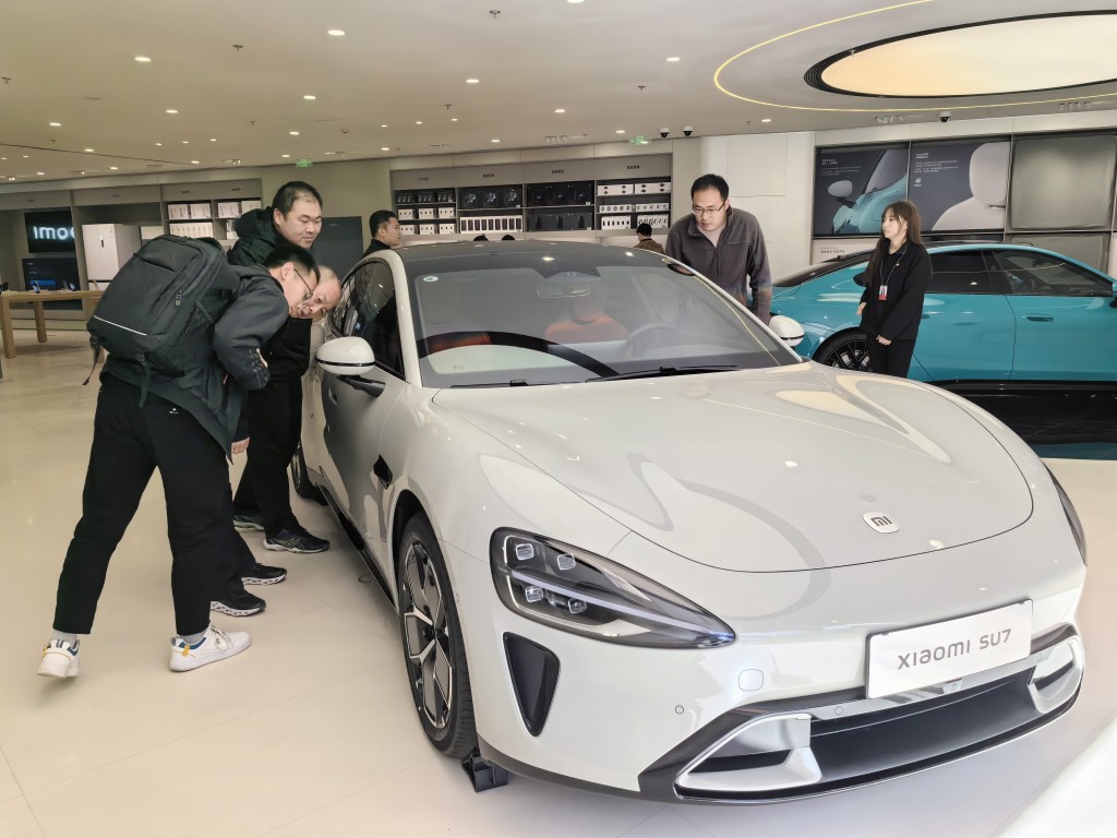 小米SU7推出後大獲歡迎，圖為北京的消費者在展銷廳在了解小米SU7。新華社