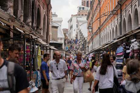 游客在威尼斯一条挤拥的街道上行走。美联社