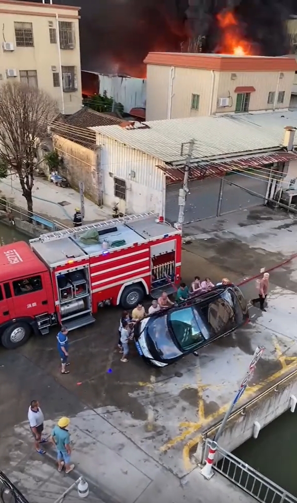 眾人合力將堵路的私家車推翻。 眾人合力將堵路的私家車推翻。
