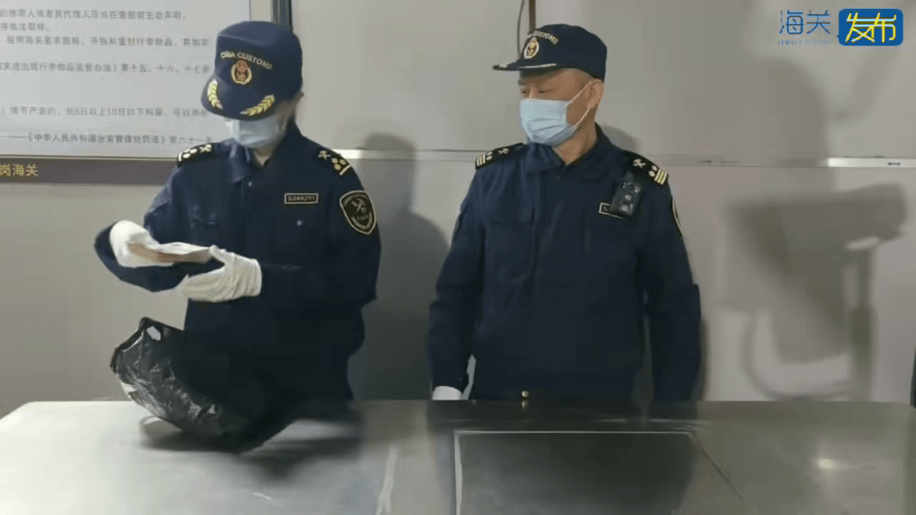 海關關員點算現金數量。海關發布