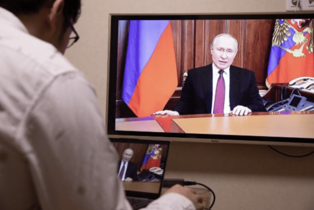 2月24日，俄罗斯首都莫斯科，记者观看普京发表讲话的电视画面。普京在讲话中宣布在顿巴斯地区发起特别军事行动。 (新华社）