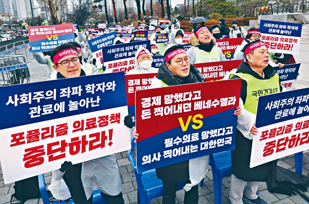 醫生周三在首爾的總統府附近示威，牌上寫着「停止民粹主義醫療政策」。