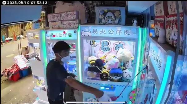 黑衫男向夾公仔機淋紅油。店主提供影片