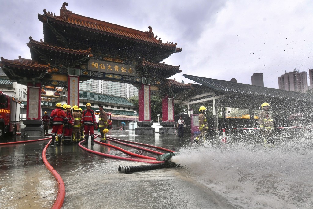 大批消防員到黃大仙中心外協助清理積水。陳極彰攝