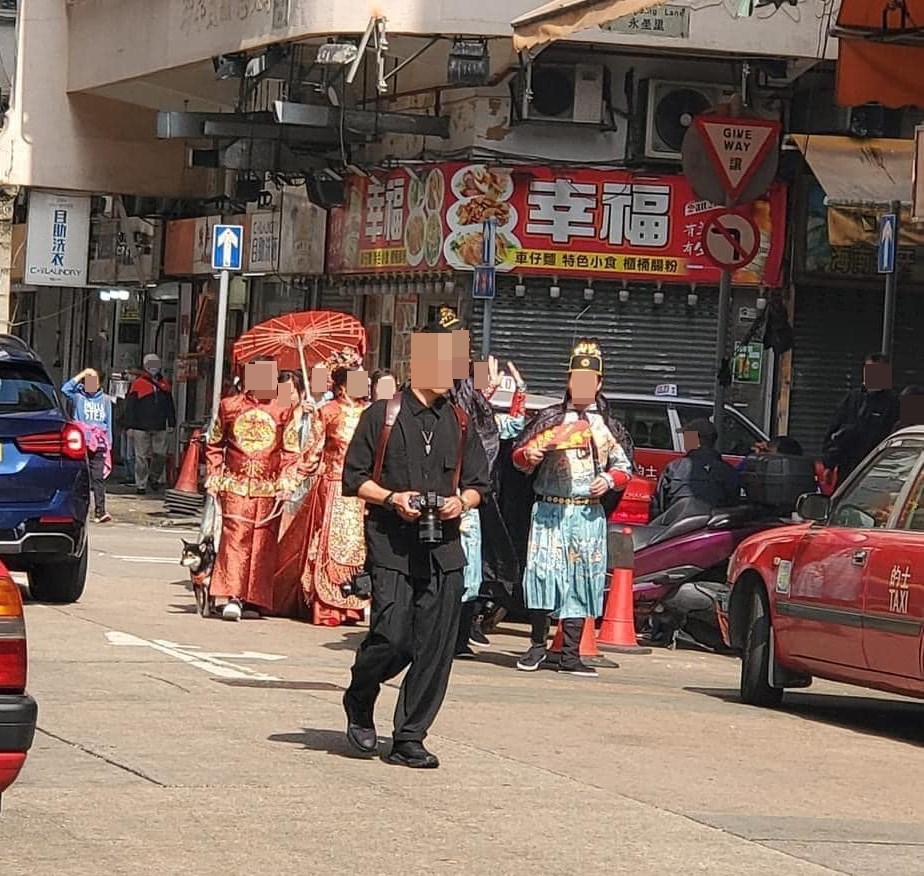 相中一行13人，包括一對新人、5名姊妹、5名戥穿石、1名攝影師，和一隻結上紅領巾的狗狗。fb「香港突發事故報料區」截圖