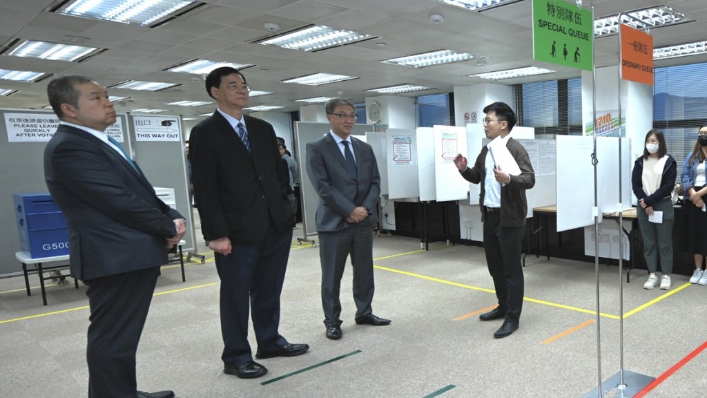 陸啟康（左三）、石丹理（左二）和文本立（左一）聽取選舉事務處工作人員簡介一般隊伍和特別隊伍的運作。政府新聞處圖片