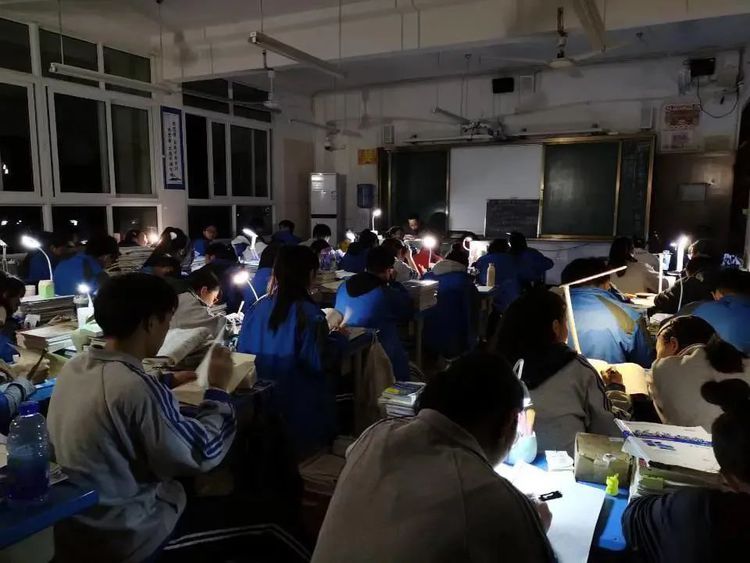 四川一所中學學生停電下自備枱燈繼續溫習。網圖