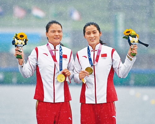 ■徐诗晓（左）与孙梦雅在雨中领取东奥金牌。