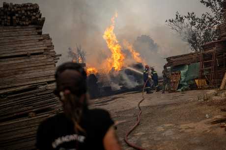 雅典附近的哈西亚村可见消防员正在扑救山火。路透社