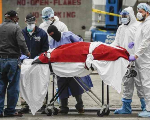 穿上保護裝束的人員把一具具遺體抬上冷藏卡車運走。AP