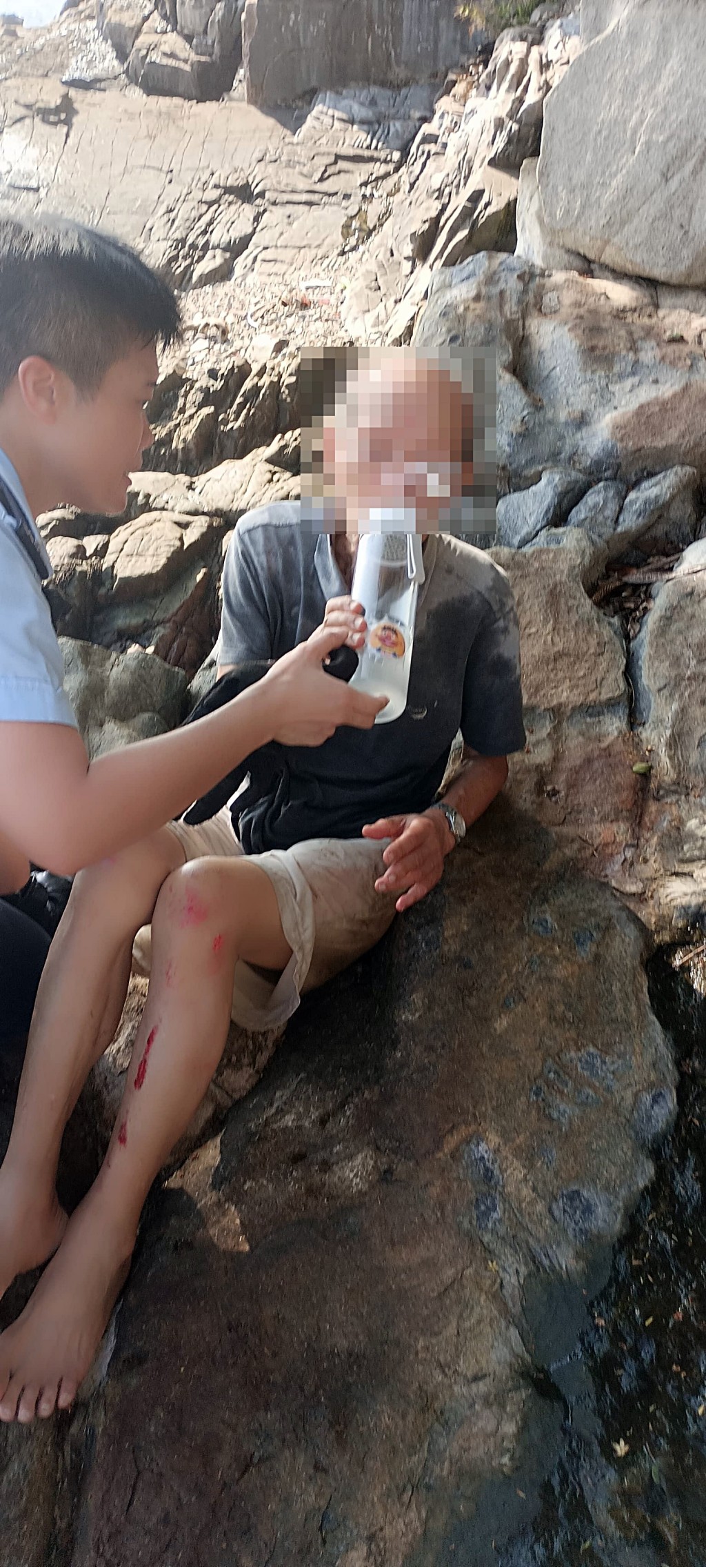 伯伯手腳擦傷,全身濕冷,警員周安琪向其提供運動飲料。 伯伯手腳擦傷,全身濕冷,警員周安琪向其提供運動飲料。