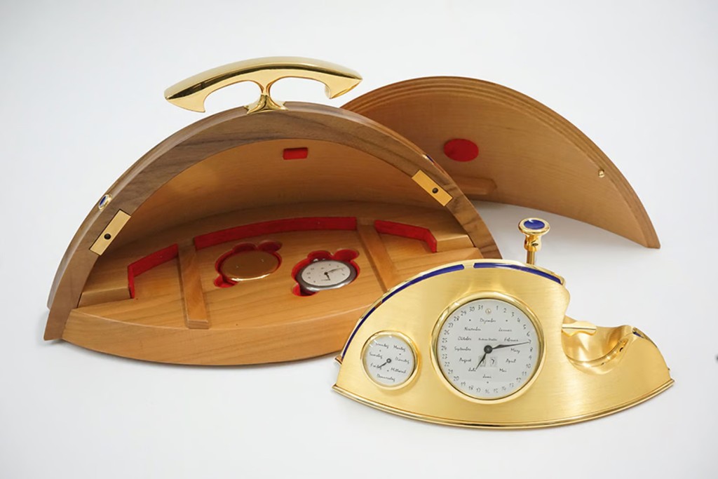 左邊錶盤顯示星期，中間大錶盤顯示月份、日期、年份，右側是大馬士革鋼製袋表。