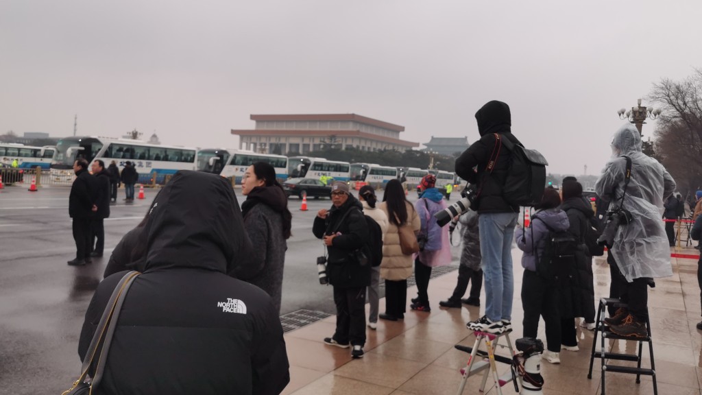 記者在雨雪天氣下等候採訪目標。　楊浚源攝