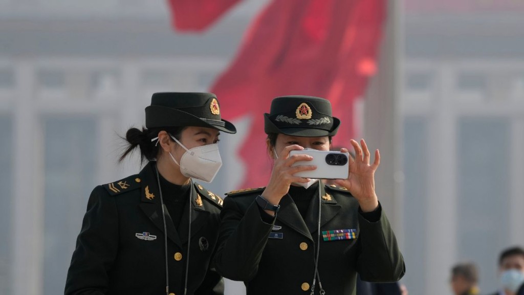 两名军队的女工作人员在天安门广场自拍。　美联社