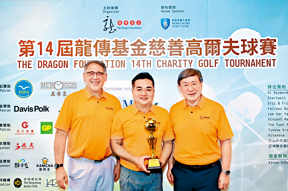 第14屆高爾夫球賽籌委會委員楊德業先生（中）作賽的「LadyM隊」勇奪「隊際總桿」總冠軍。頒獎嘉賓：龍傳基金主席黃嘉純律師（左一）、卓永興副司長（右一）。