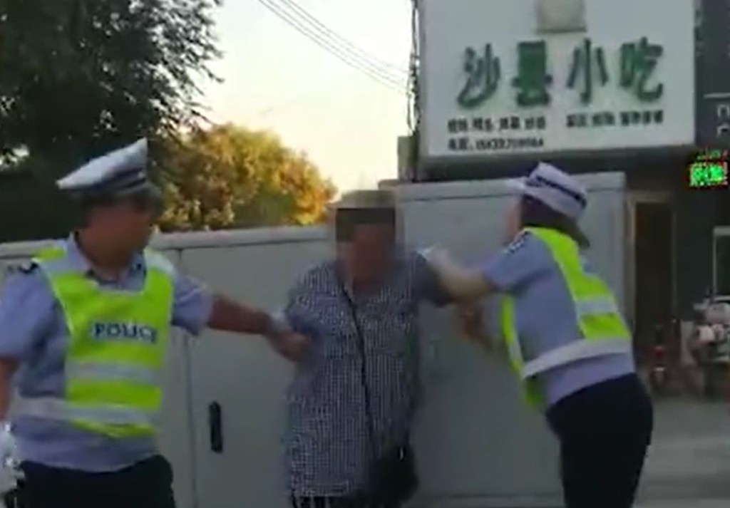 女子在路上逆線踩單車被截停,竟出手打傷女輔警。網圖