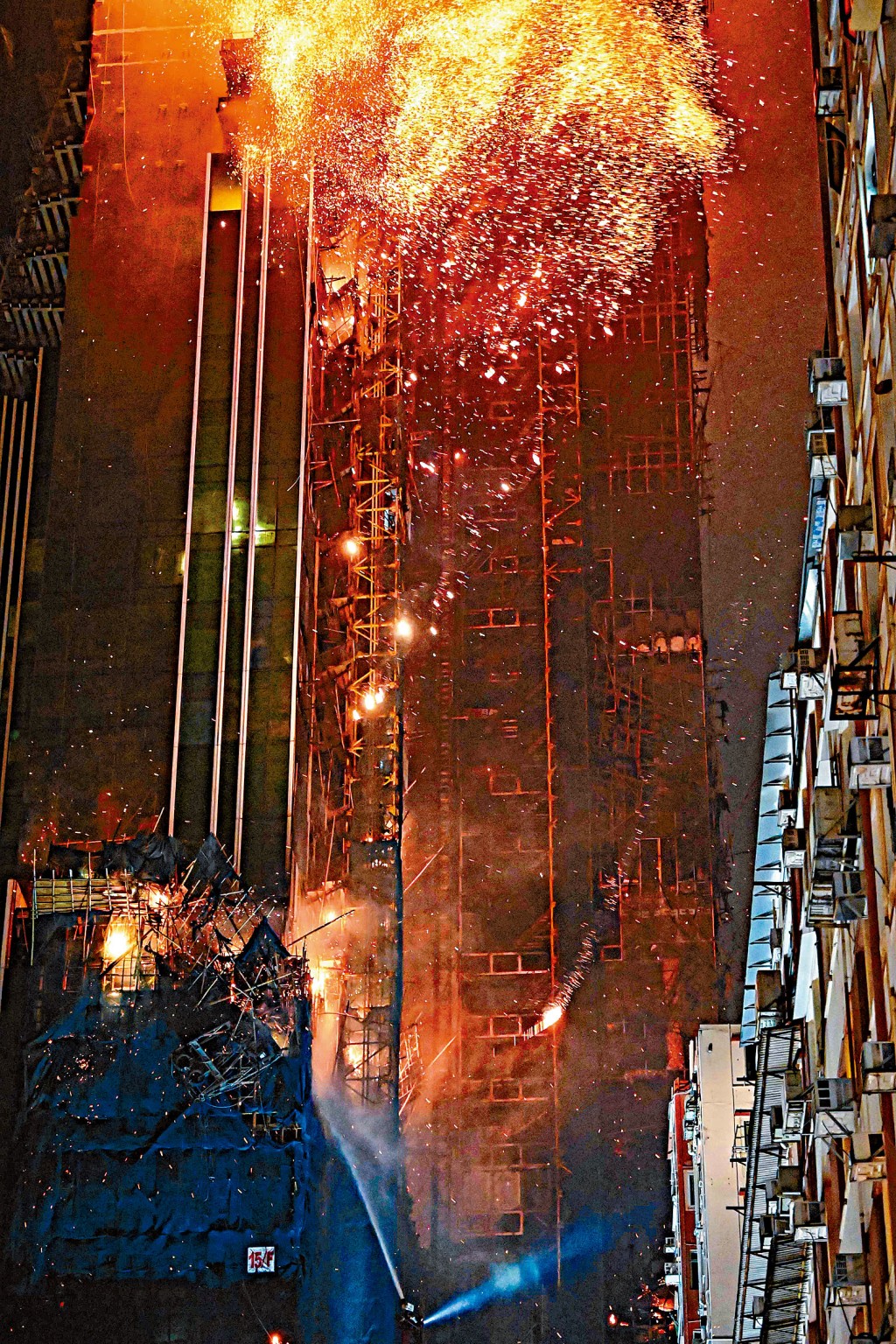 尖沙嘴中間道地盤前晚深夜起火，大量火屑隨風勢吹向其他大廈。