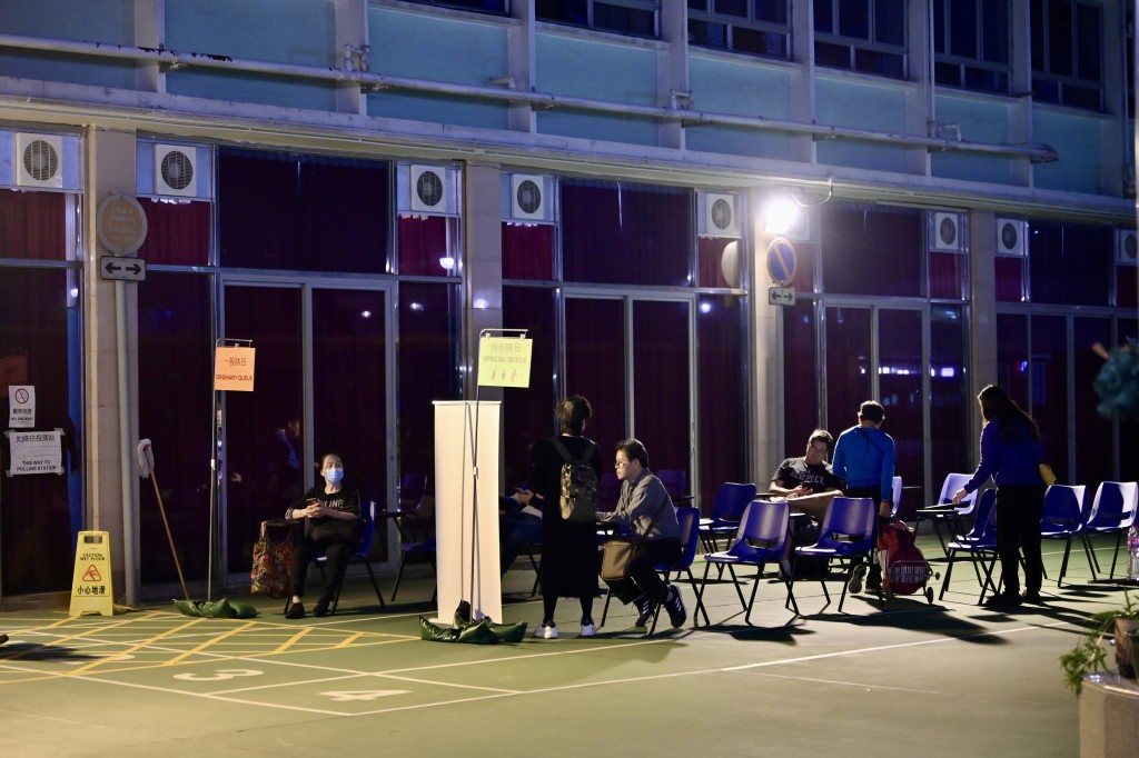 新蒲崗保良局陳南昌夫人小學投票站，因投票系統出現故障，市民需在戶外排隊等候票站重開。鍾健華攝