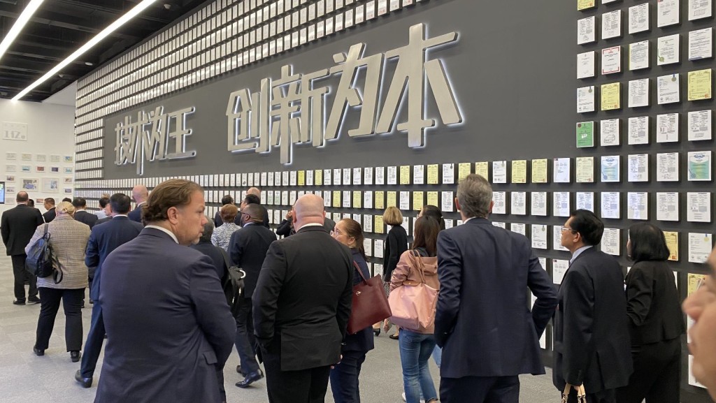 参访团来到深圳比亚迪总部，专利展示墙上张贴著数以千计的专利证书。梁伊琪摄