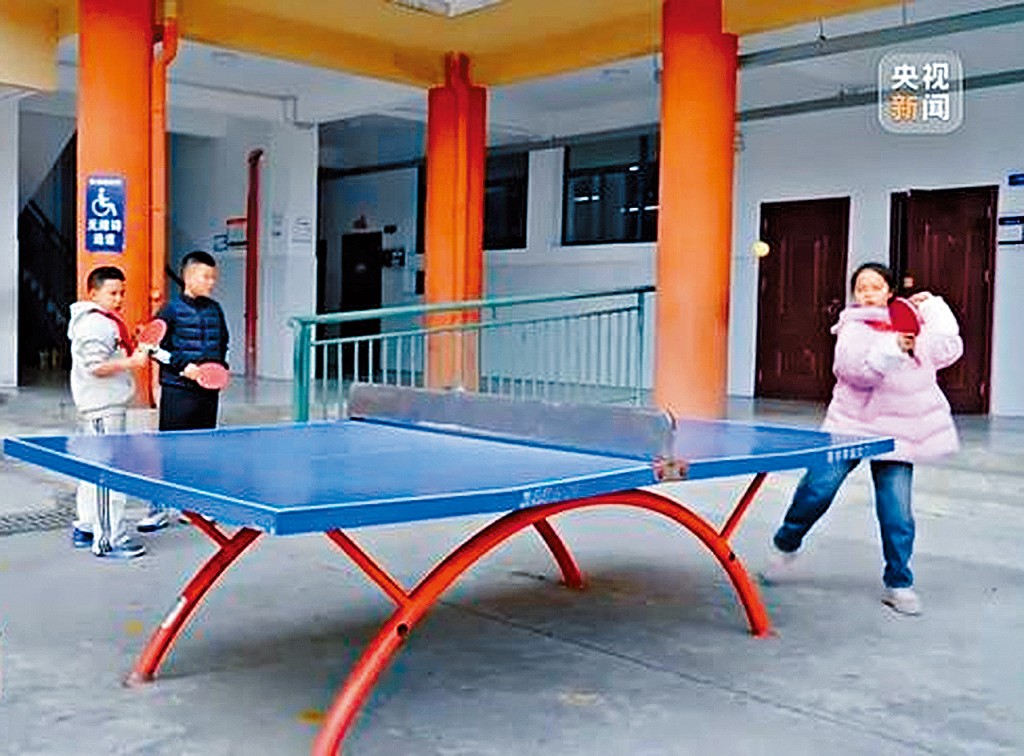 学生在体育课上打乒乓球。