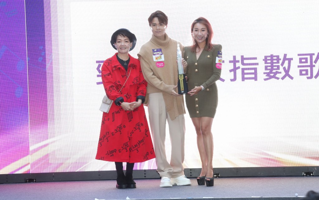 新城知讯台节目总监程凯欣（左）在记者会颁今年第一个乐坛奖项给张敬轩。