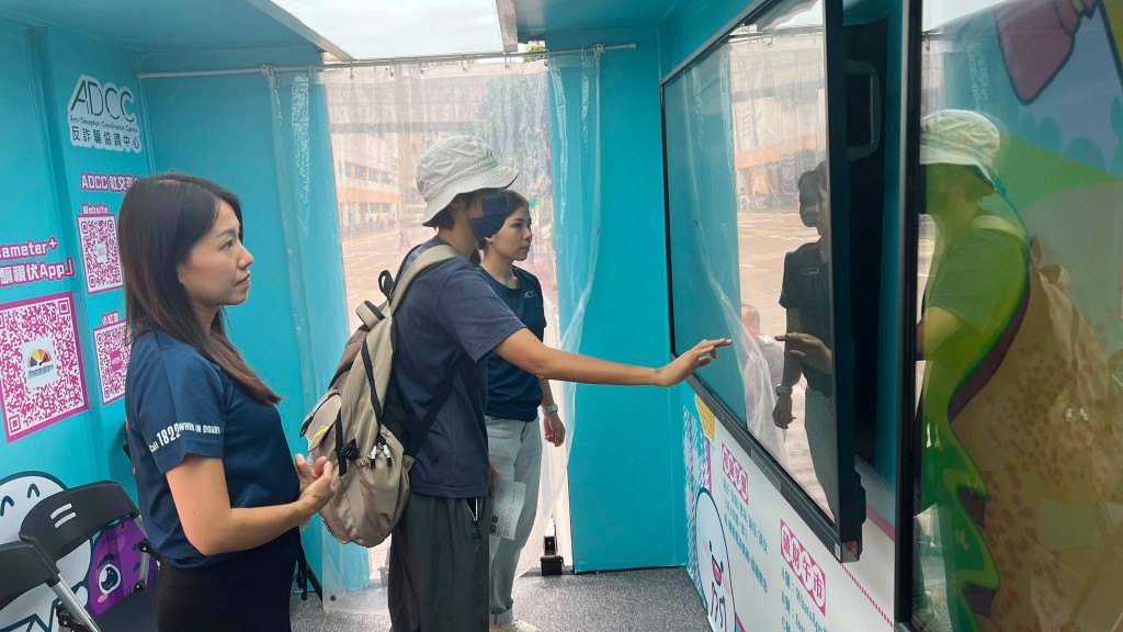 警務處反詐騙協調中心警長列慧芬(左)在防騙宣傳車活動中向協助市民了解防騙資訊。 警務處反詐騙協調中心警長列慧芬(左)在防騙宣傳車活動中向協助市民了解防騙資訊。