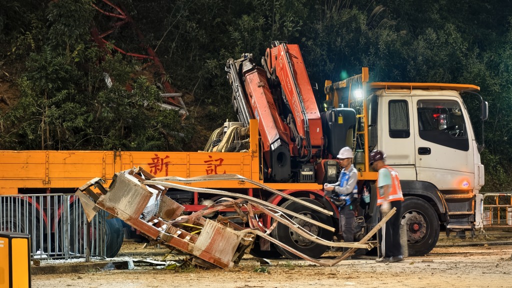 工人將金屬殘骸吊走。黃文威攝