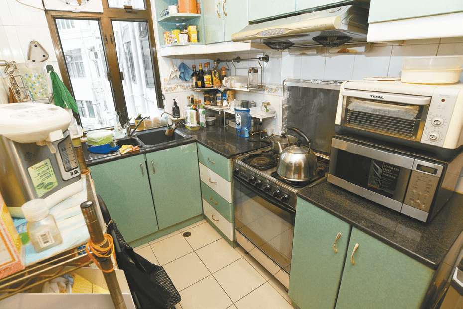 厨房已有暗绿和黑色工作台和厨柜，方便住户日常清洁。