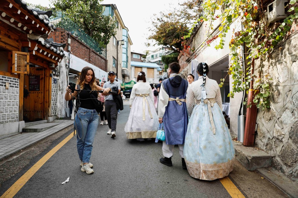 有穿著韩服人士在韩屋村游走。路透社