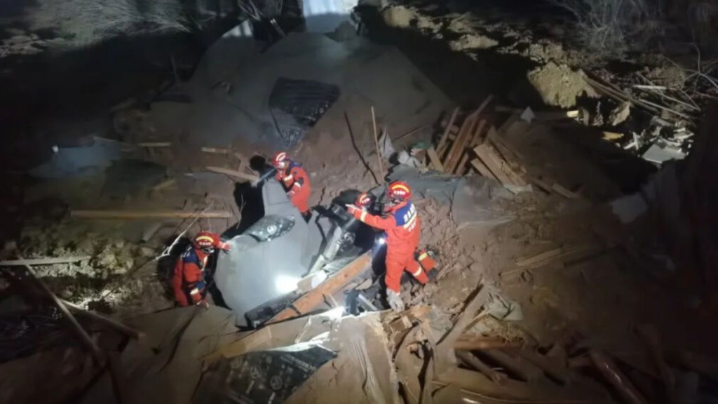 消防人員在倒塌房屋中搜救生還者。新華社