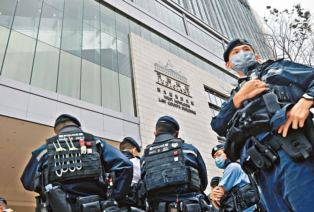 西九龍法院昨審立法會初選案，法院玻璃幕牆被射爆，大批警員到場戒備。