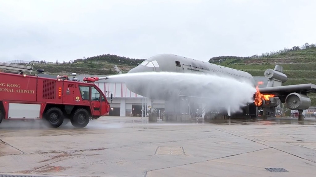 水炮車向模擬着火的飛機射水。影片截圖