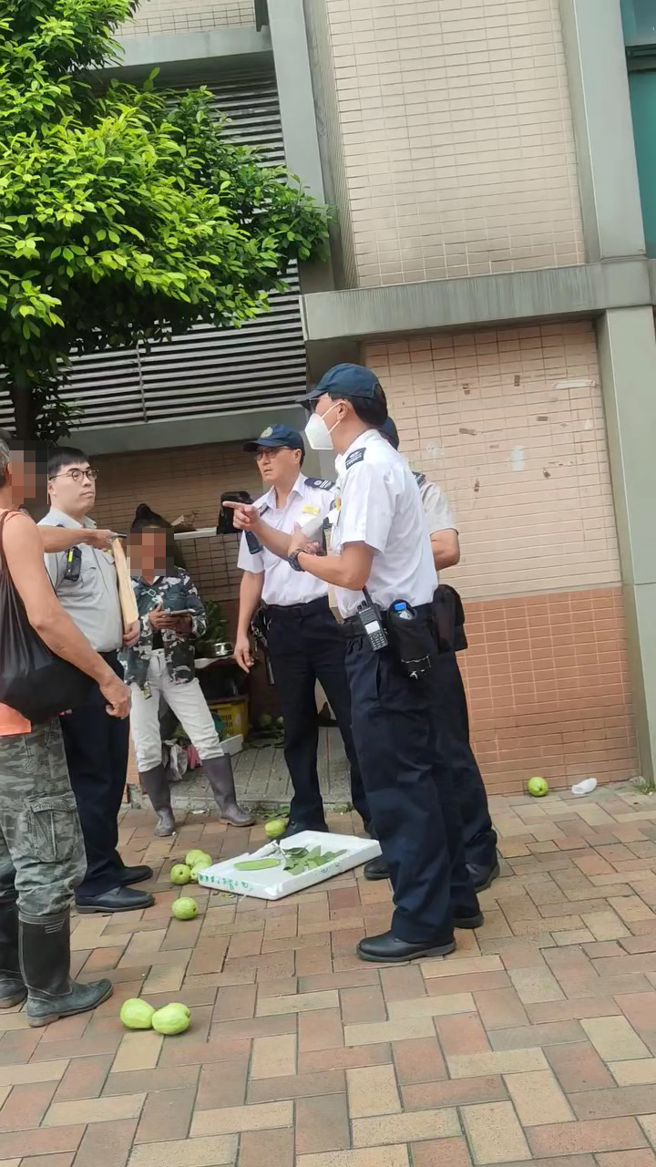 一名食环署职员问两档主地上的生果属于何人，但两人支支吾吾否认。网上片段截图