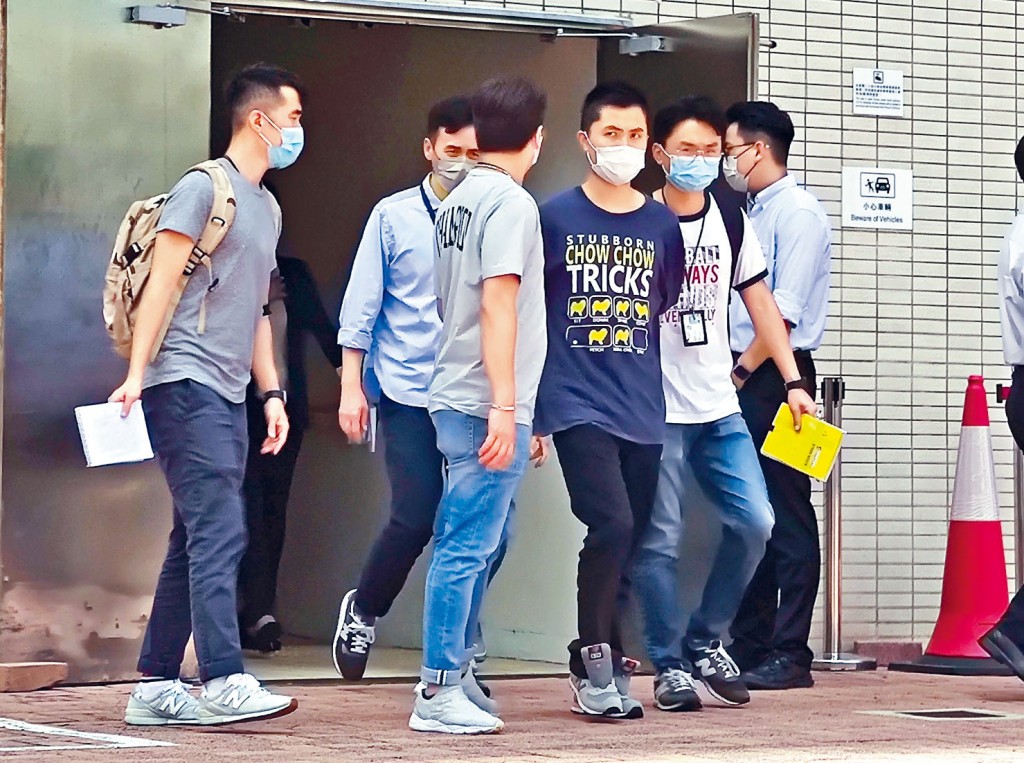 被捕浸大職員杜倚獅（右三），由探員押返沙田石門浸大國際學院調查。
