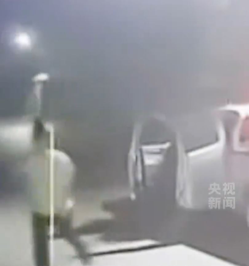 白衣男逃出车后，夺力救出后座1男2女中国同胞。央视