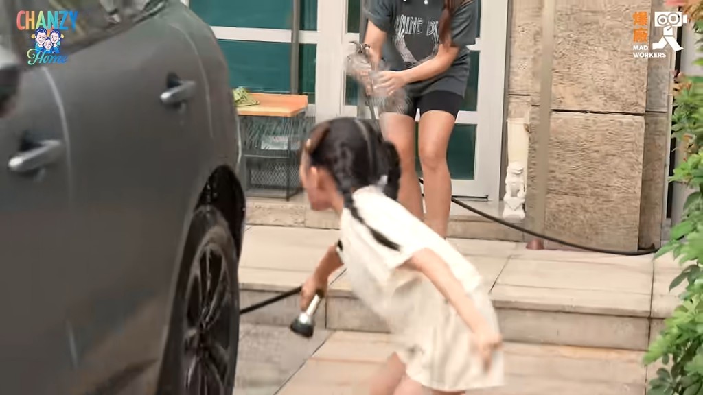 小豬比專注地用水喉沖洗車輪。 小豬比專注地用水喉沖洗車輪。
