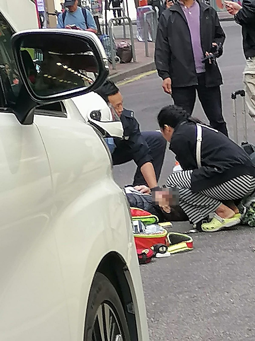 老婦事後昏迷地上，外傭陪在身旁。