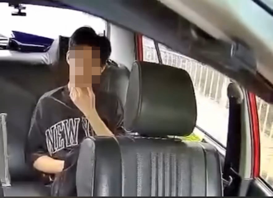 一名青年坐在的士左邊後座,不時四處張望。 一名青年坐在的士左邊後座,不時四處張望。