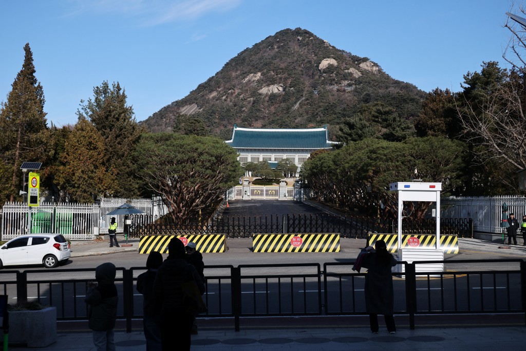 12月22日，遊客在韓國首爾的青瓦台門前拍照。 路透社