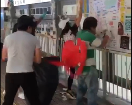 一名穿着灰色上衣男子,突然向撕連儂牆的人士淋紅油。影片截圖
