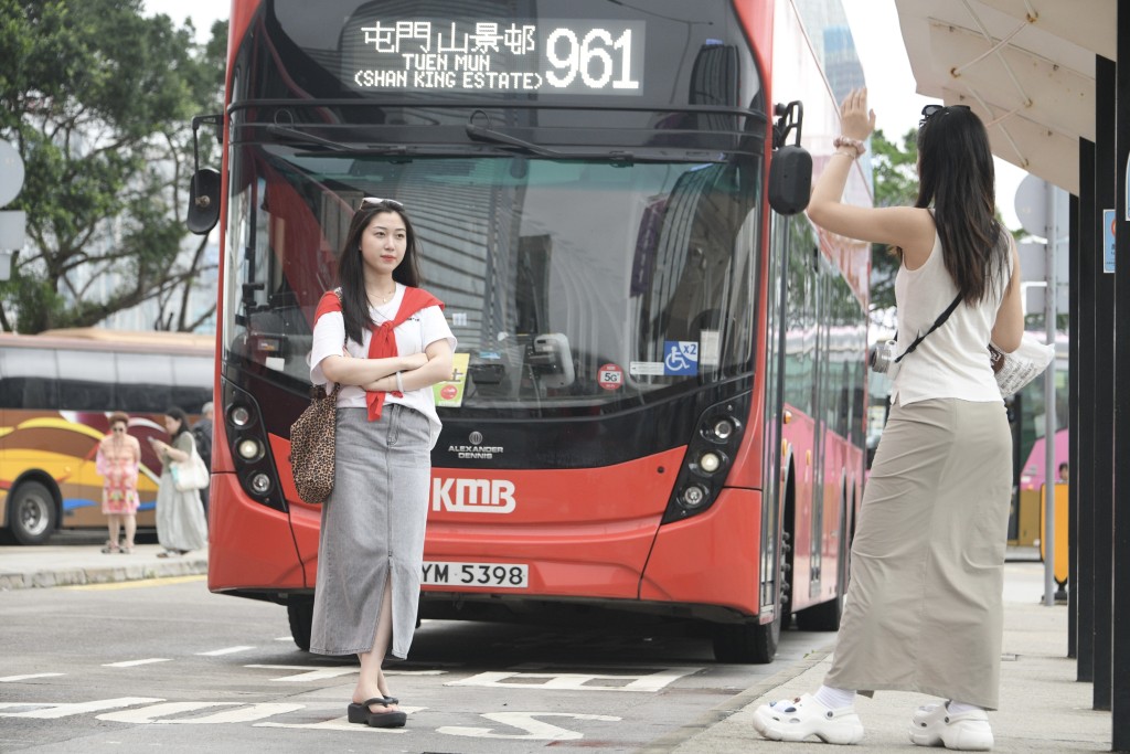 游客与双层巴士合照。