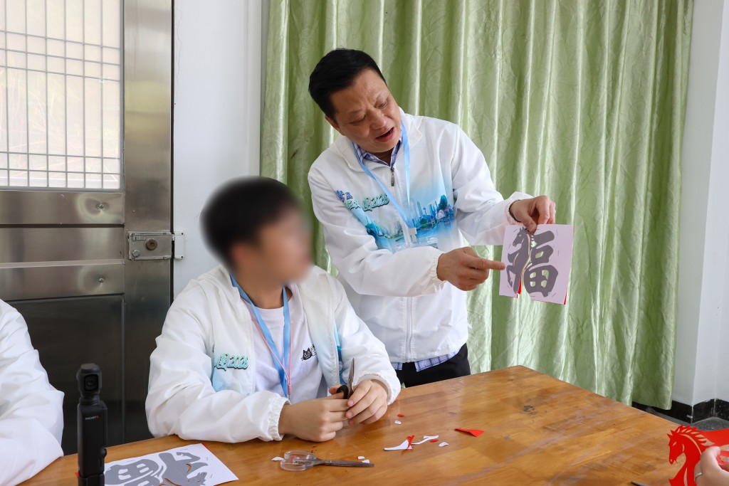 活動贊助人夏中建（右）帶領青少年更生人士到佛山一間學校體驗中國傳統手工藝，了解源遠流長的中國歷史與文化底蘊。政府新聞處圖片