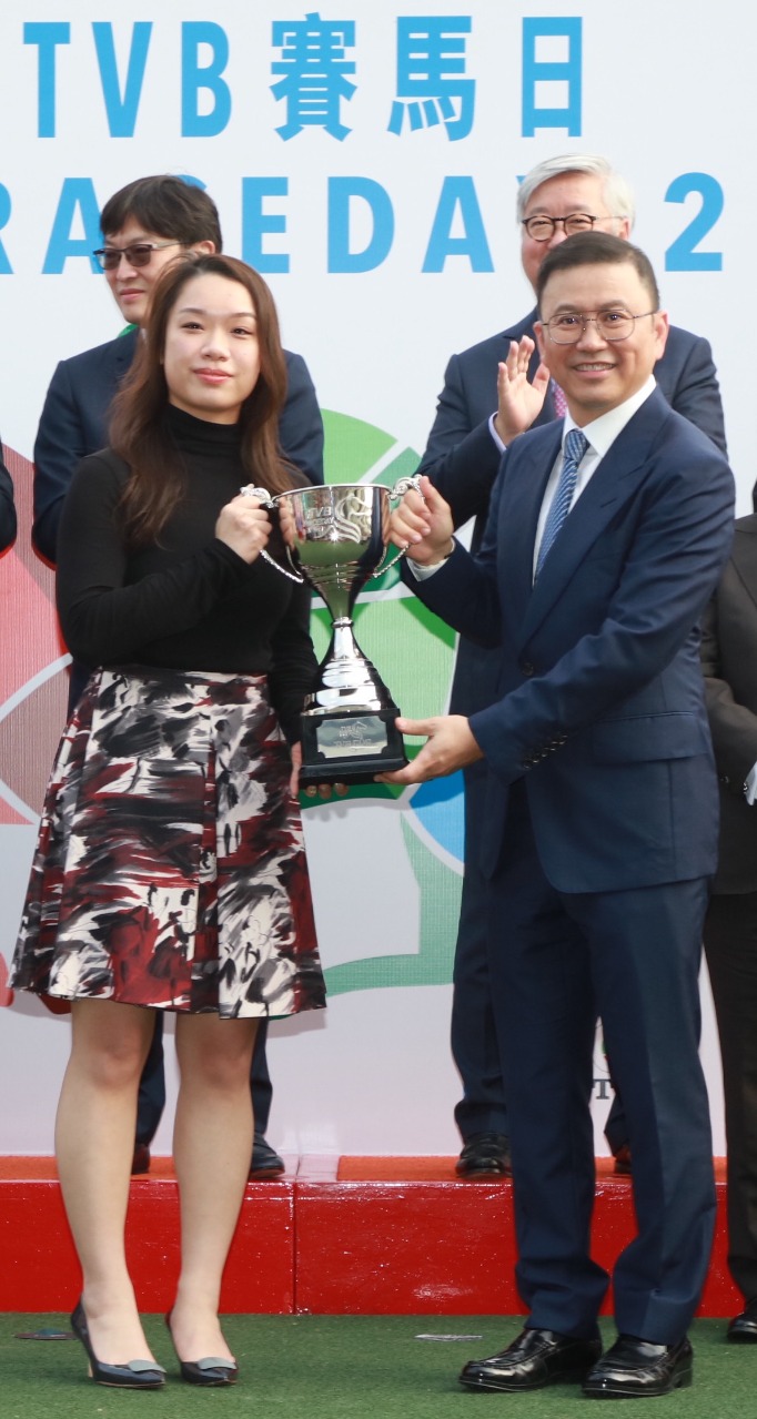 电视广播有限公司主席许涛先生（右）颁发TVB杯予「健康快驹」的马主黄文莉。