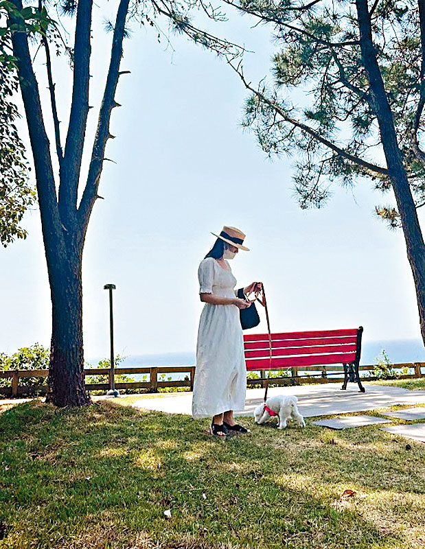 另一张拖狗相中，珍妹疑似用右手遮掩腹部。