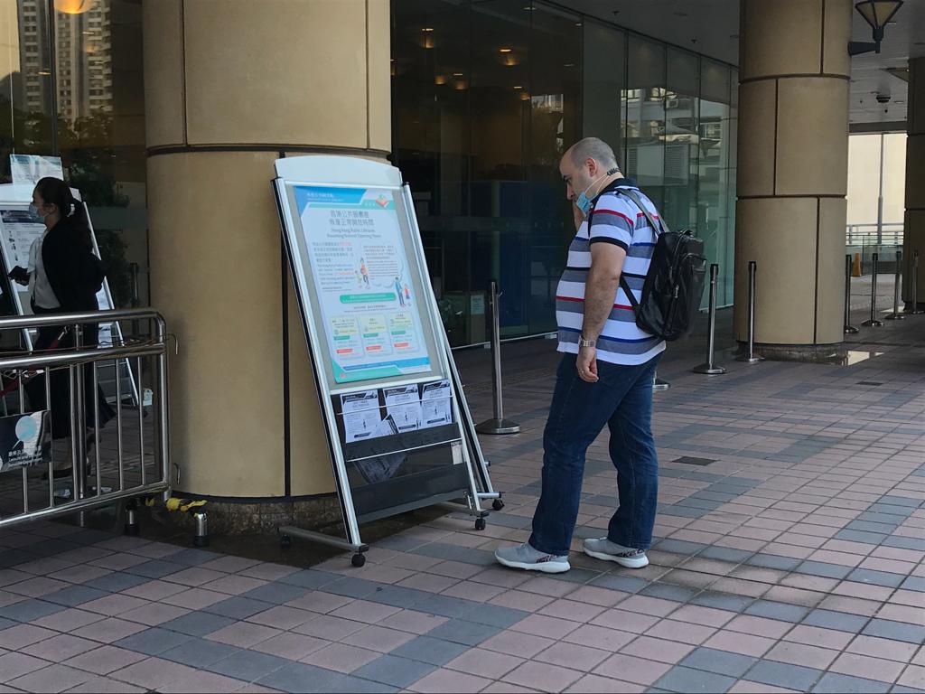 市民在一旁觀看開放時間資料,未有留意二維碼。