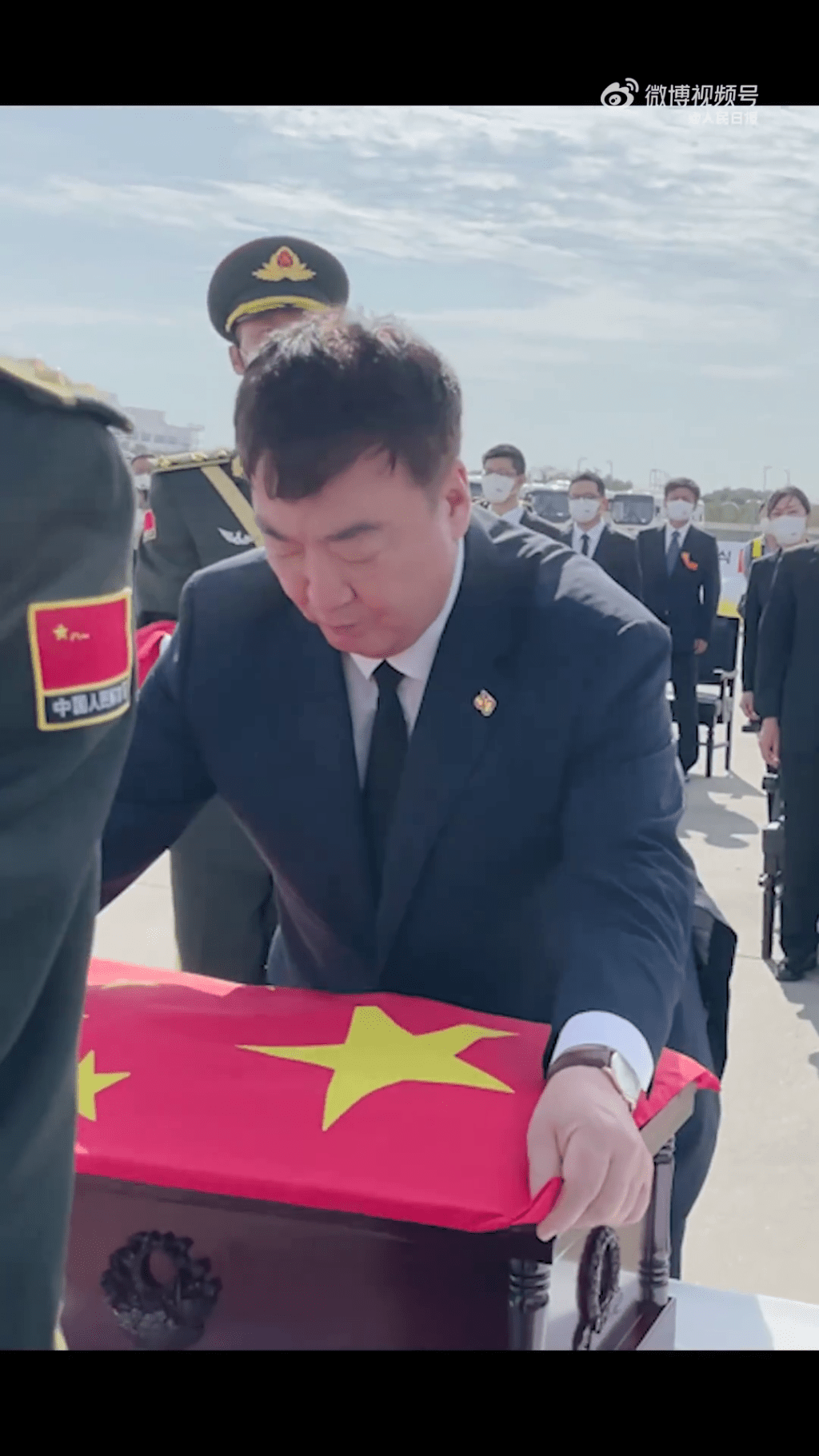 中国驻韩国大使为志愿军烈士棺椁覆盖国旗。