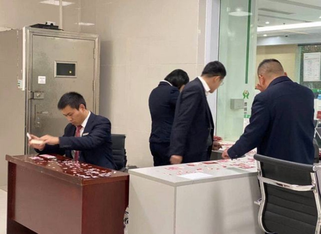 銀行安排多名職員連日拼貼人民幣。互聯網圖片