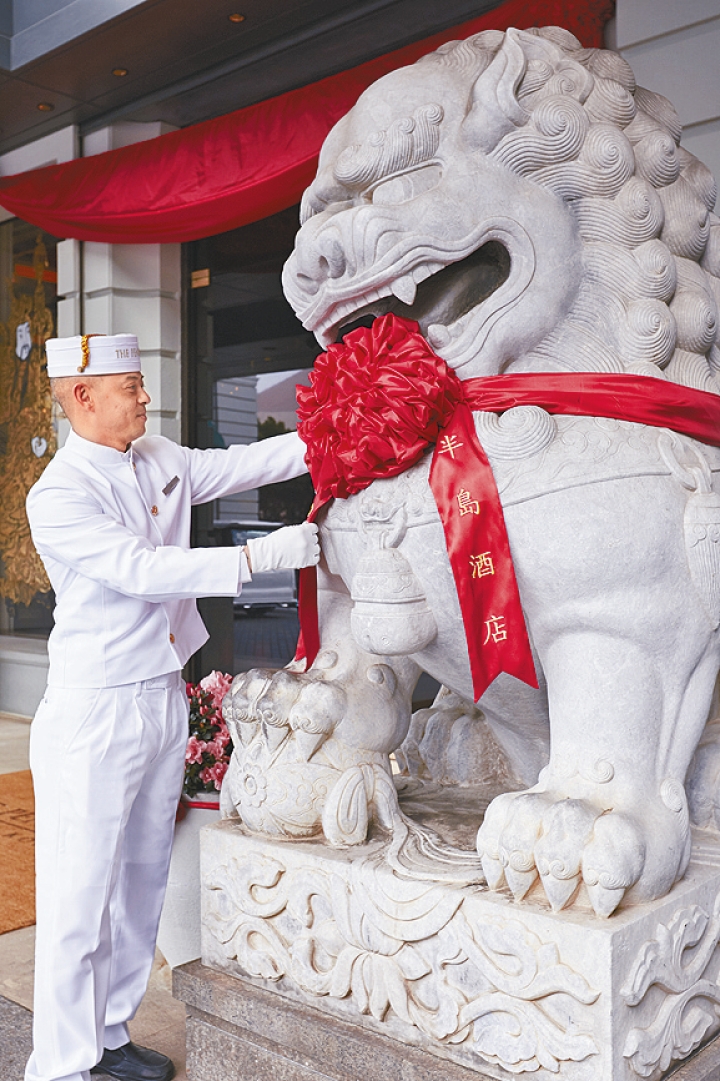 香港半島酒店正門外的石獅子，參花掛紅迎新歲。