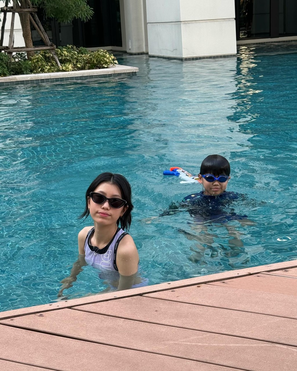 Emma与戴泳镜Evan就在泳池玩水。