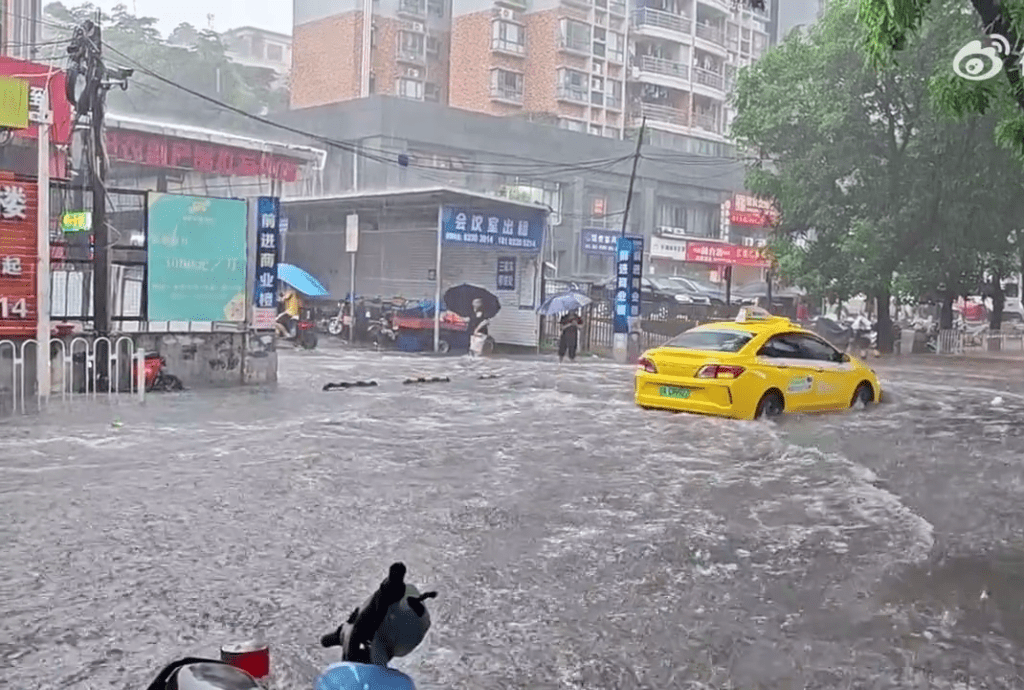 广东暴雨下，市面的情况，汽车在水面行驶。